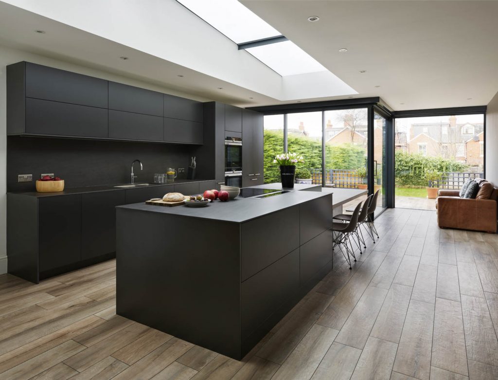Modern, contemporary kitchen with abstract island in a white and dark grey finish with casual seating and Gaggenau appliances